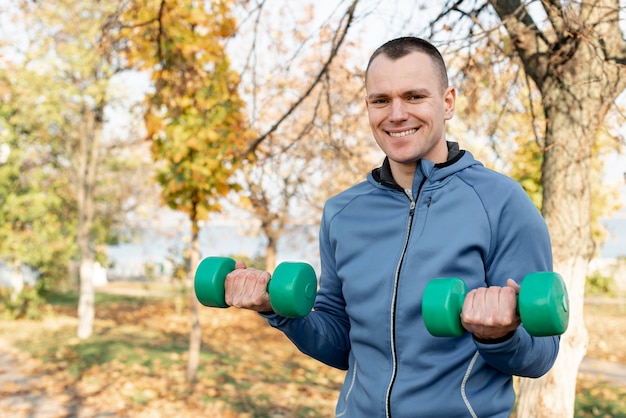 自然の中でフィットネス運動をしているハンサムな男