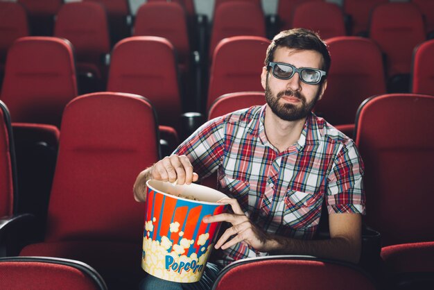 映画の中でポップコーンを食べるハンサムな男