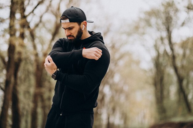 Handsome man exercising in park in sports wear