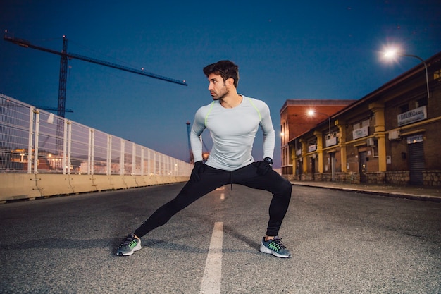 Handsome man exercising on road