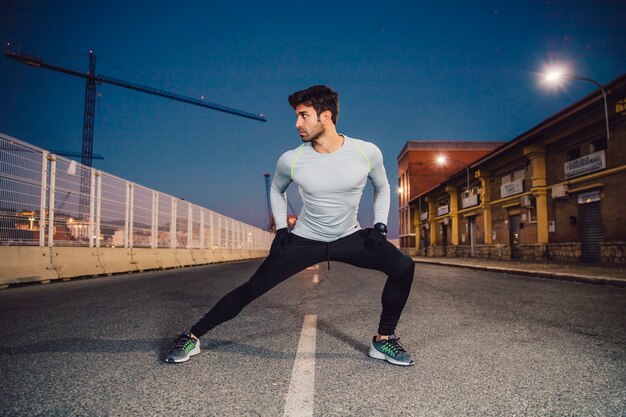 Handsome man exercising on road
