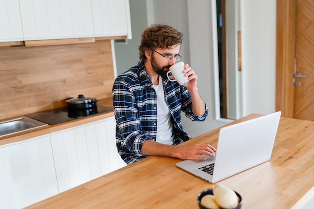 Handsome man freelancer using laptop studying online working from home