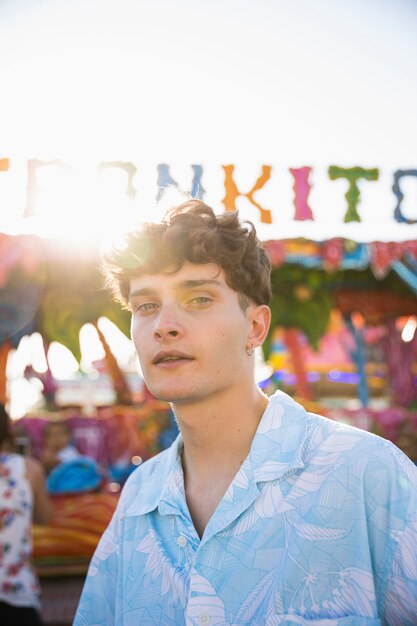 Handsome man at funfair looking at camera