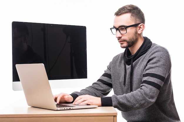 Uomo bello in vetri che lavorano al computer portatile