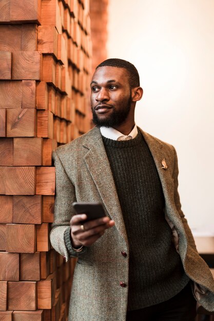 Handsome man in grey jacket holding his phone