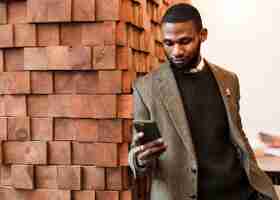 Free photo handsome man in grey jacket looking at his phone