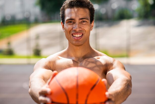 Handsome man holding a ball  medium shot