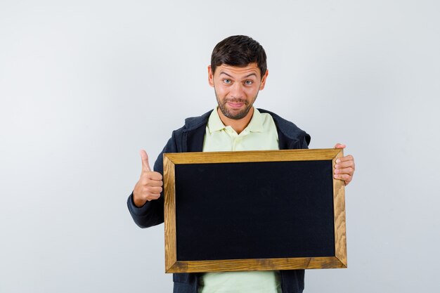 Handsome man holding a blackboard in a casual outfit