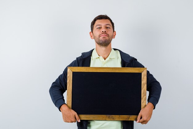 Handsome man holding a blackboard in a casual outfit