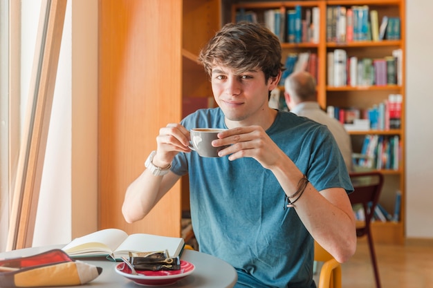 Foto gratuita uomo bello che tiene tazza in mano