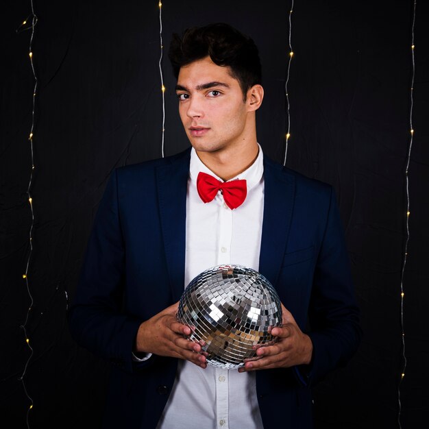 Handsome man holding disco ball