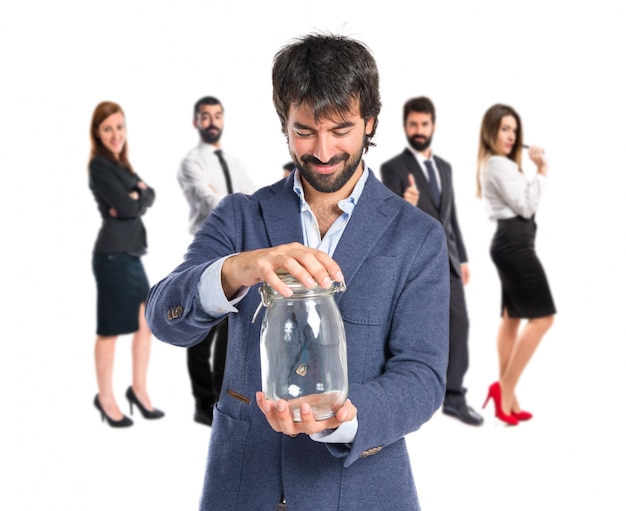 Handsome man holding an empty glass jar over isolated background