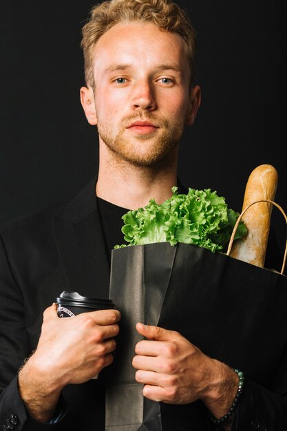 Handsome man holding groceries bag