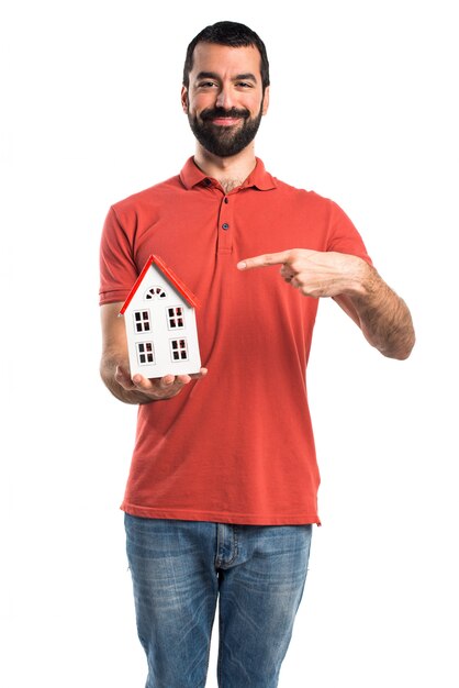 Handsome man holding a little house