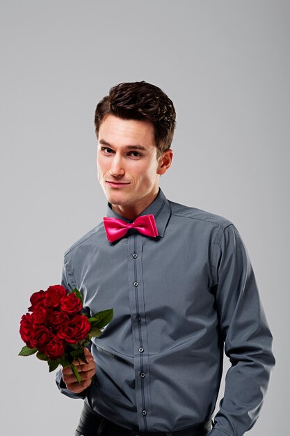 Handsome man holding red roses