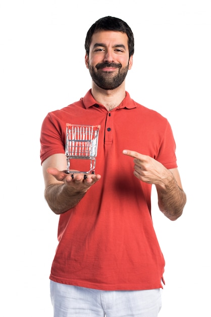 Handsome man holding a supermarket cart toy