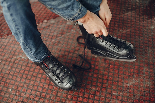 Foto gratuita bell'uomo in un'arena di ghiaccio con skate