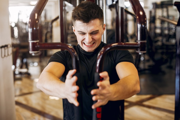 Foto gratuita un bell'uomo è impegnato in una palestra