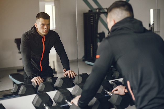 Foto gratuita un bell'uomo è impegnato in una palestra