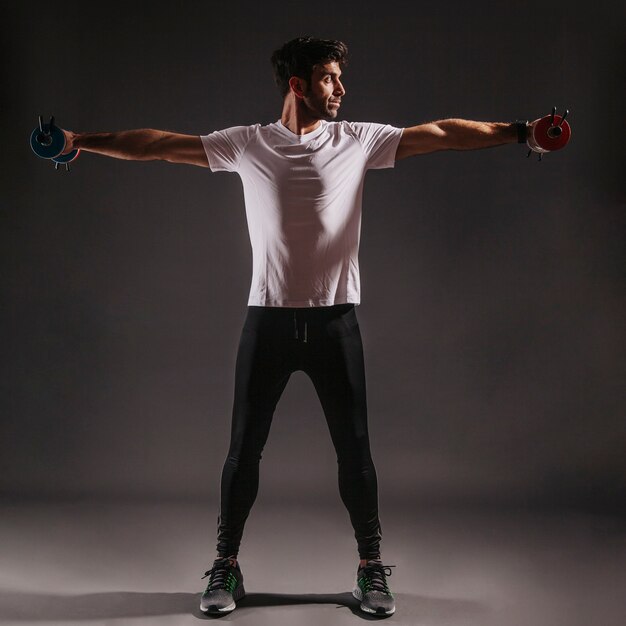 Handsome man lifting dumbbells