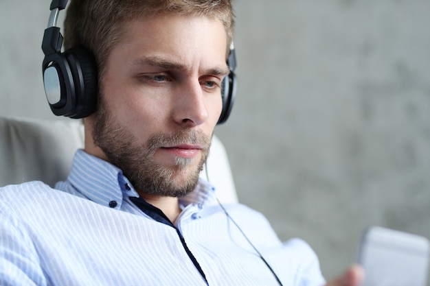 Handsome man listening music on headphones