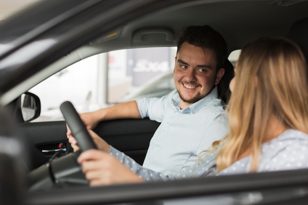 Uomo bello che esamina driver femminile