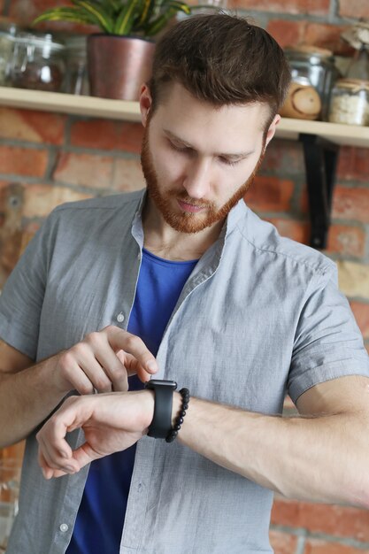 Handsome man looking at his wrist watch