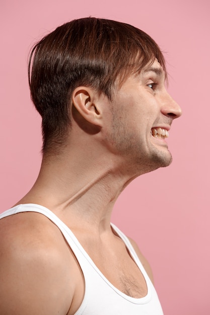 Handsome man looking suprised isolated on pink wall