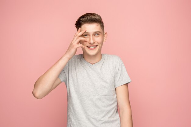 Handsome man looking suprised isolated on pink