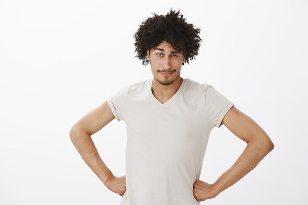 Foto gratuita uomo bello che sembra sospettoso con le mani sulla vita, persona che rimprovera