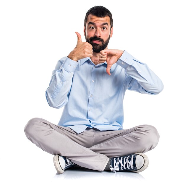 Handsome man making good-bad sign