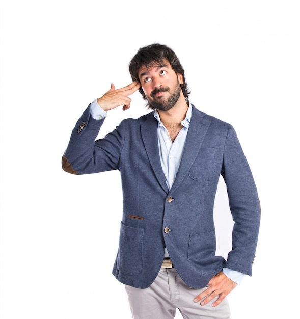Handsome man making suicide gesture over white background