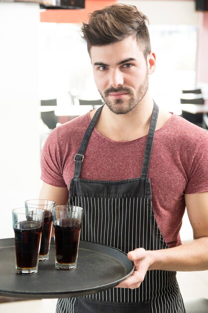 Handsome man offering drinks in the bar