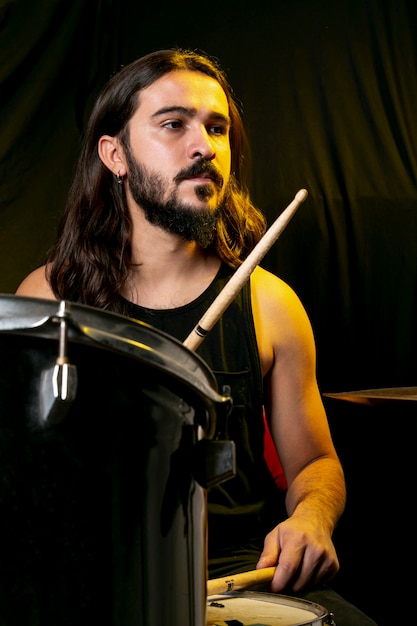 Handsome man playing drums with sticks