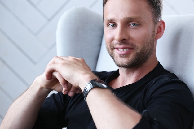 Handsome man posing on the armchair