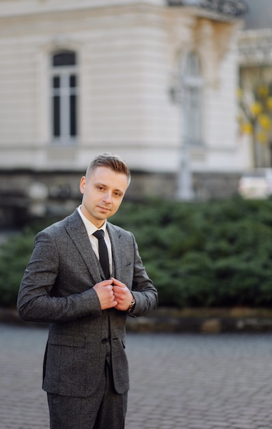 Handsome man posing in wedding suit in the streets