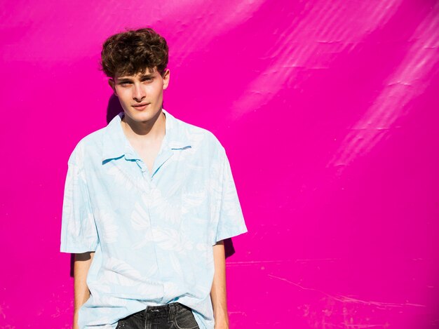 Handsome man posing with pink wall