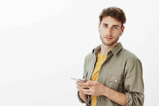 Free photo handsome man posing with smartphone in the studio