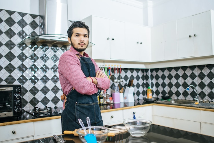 मुफ़्त फोटो handsome man preparing stuff for cooking at home.
