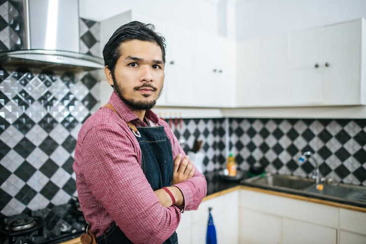 मुफ़्त फोटो handsome man preparing stuff for cooking at home.