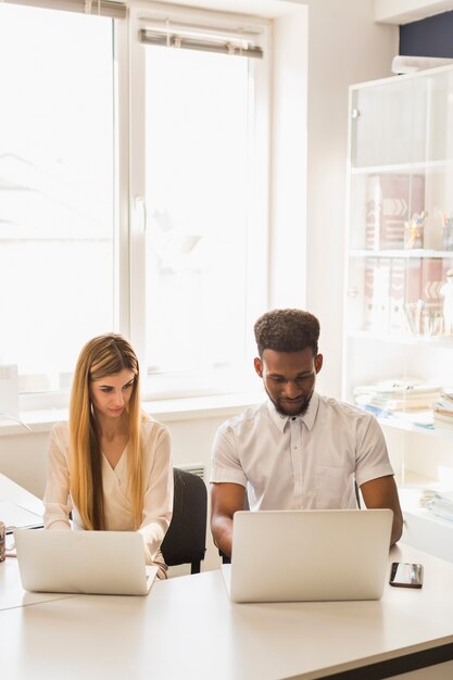 Handsome man and pretty woman working in office