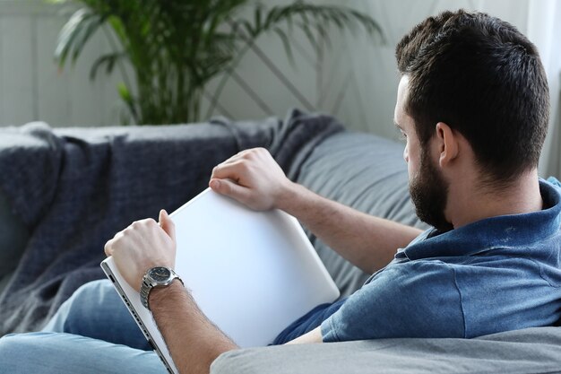 Handsome man reading a book in the couch