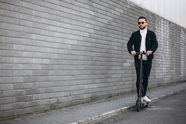 Handsome man riding in town on scooter