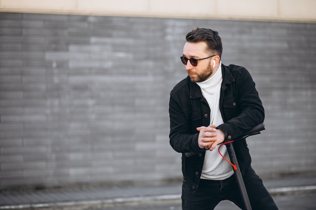 Handsome man riding in town on scooter