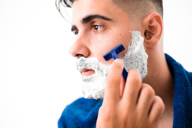 Free photo handsome man shaving his beard close-up