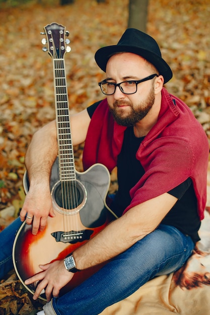 Handsome man sitting in a autumn park