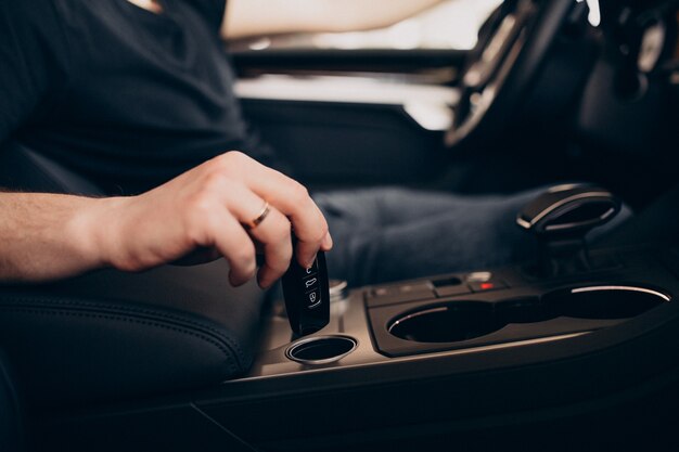 Handsome man sitting in car and testing it