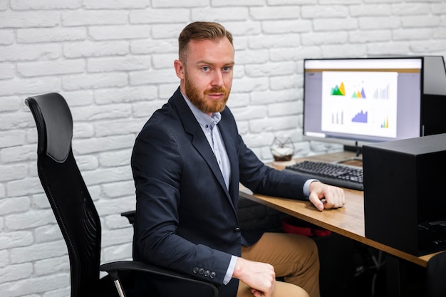 Free photo handsome man sitting at desk