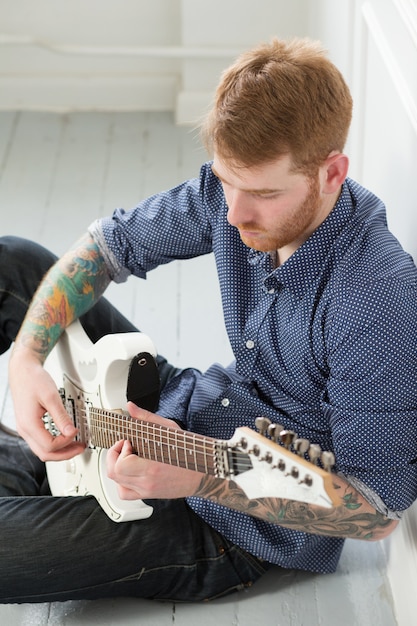 Free photo handsome man sitting on the floor