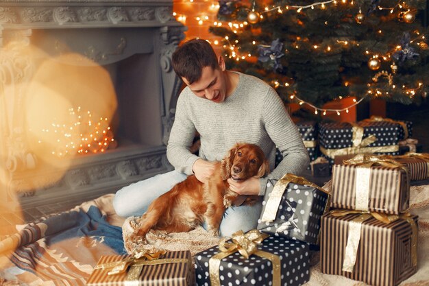 Handsome man sitting hear fireplace with a dog